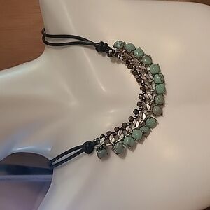Fossil necklace with green stones and silver color.